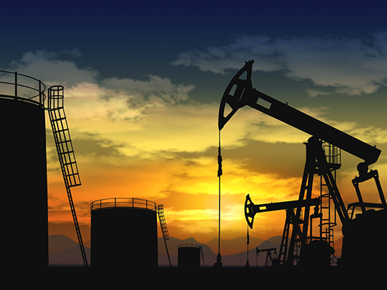 Oil field with multiple pumps and storage tanks at sunset, representing cybersecurity deployment for energy infrastructure and regulatory compliance.
