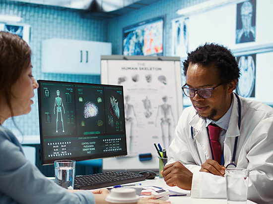 Doctor discussing patient information and next steps with a patient, as medical data is displayed on a computer screen, highlighting cybersecurity in healthcare.